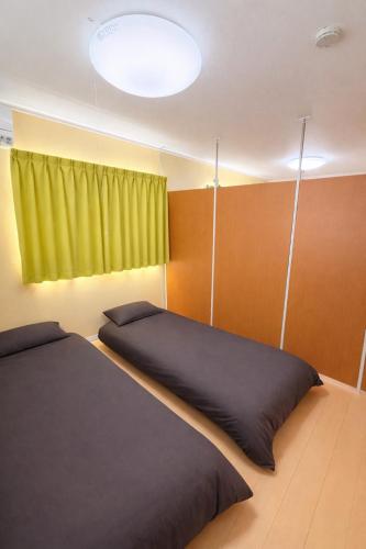 En eller flere senge i et værelse på Guesthouseとき2