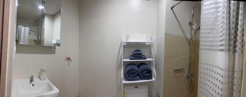 a bathroom with a sink and a toilet with blue towels at Mattys Crib Tower C Unit 204 in Iloilo City
