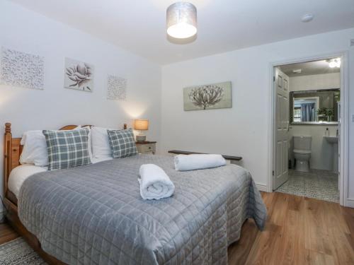 a bedroom with a bed with two towels on it at Tŷ Gareg in Gaerwen