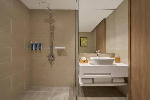 a bathroom with a shower with a sink and a toilet at Four Points by Sheraton Nha Trang in Nha Trang