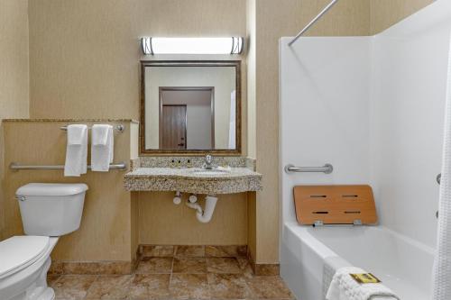 a bathroom with a sink and a toilet and a mirror at Best Western Plus Capital Inn in Jefferson City
