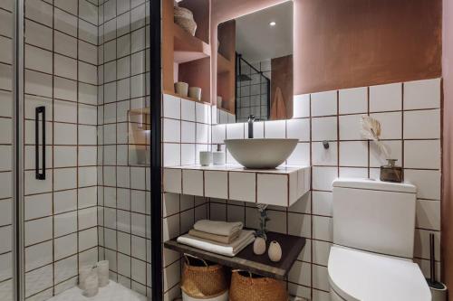 a white tiled bathroom with a sink and a toilet at Impressive beachfront home in Calafell