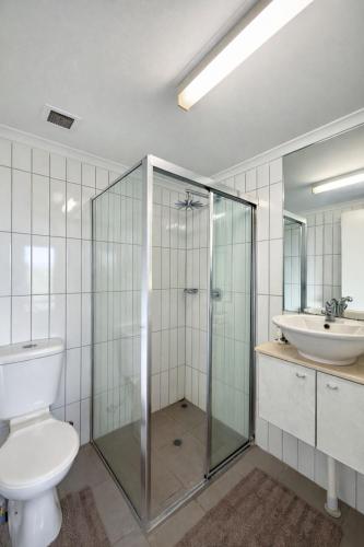 a bathroom with a shower and a toilet and a sink at Zen Marina Studio: bayview - shared pool - central in Larrakeyah