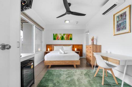 a bedroom with a bed and a desk and a table at Zen Marina Studio: bayview - shared pool - central in Larrakeyah