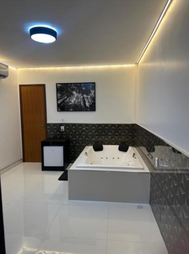 a bathroom with a bath tub in a room at Hotel Paraiso Go in Valparaíso de Goiás
