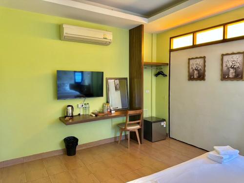 a room with a desk and a television on a wall at Excellence Pool Villa in Na Jomtien