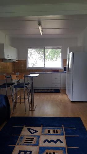 a kitchen with a table and a refrigerator at Redtail Cottages in Hester