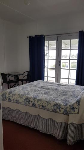a bedroom with a large bed with blue curtains at Redtail Cottages in Hester
