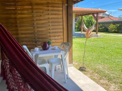 a table and chairs on the porch of a house at Morada Carmem in Praia do Rosa