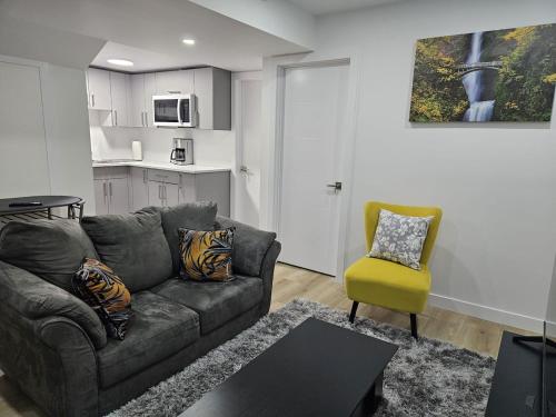 a living room with a couch and a yellow chair at Transcona Stay in Winnipeg
