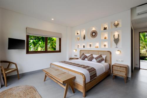 a bedroom with a large bed and a table at Villa Fafa by BaliSuperHost in Ubud