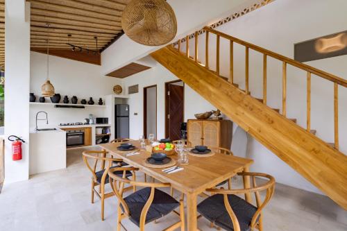 a kitchen and dining room with a wooden table and chairs at Villa Fafa by BaliSuperHost in Ubud