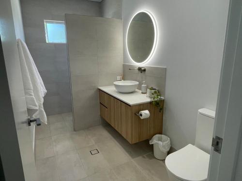 a white bathroom with a sink and a mirror at Silver Sands Villa in Mandurah