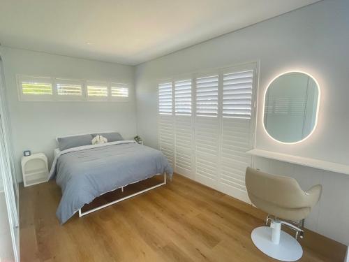 a bedroom with a bed and a chair in it at Silver Sands Villa in Mandurah