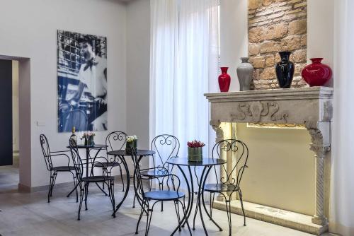 a dining room with tables and chairs and a fireplace at Via Veneto Prestige Rooms in Rome