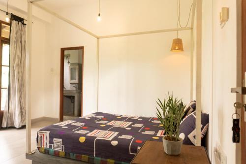 a bedroom with a bed and a table with a plant at Idam Villa in Akmimana