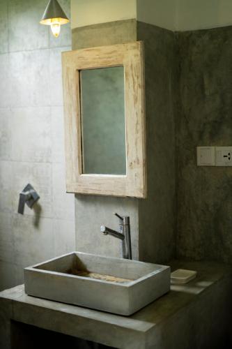 a bathroom with a sink with a mirror and a mirror at Idam Villa in Akmimana