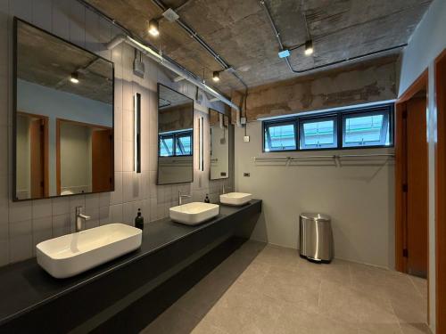 a large bathroom with two sinks and two mirrors at Once Again Hostel in Bangkok