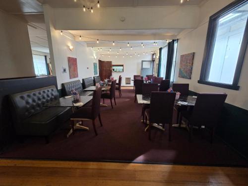 a dining room with tables and chairs in a restaurant at The Caramut Hotel in Caramut