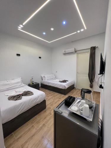 a hotel room with two beds and a desk with at Cairo City Inn Hotel in Cairo