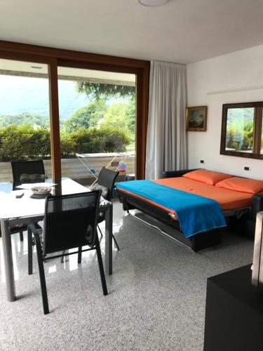 a bedroom with a bed and a table and chairs at Mergozzo Beach in Mergozzo