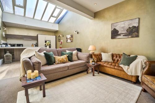 a living room with a brown couch and a skylight at 1 The Kings within the City Walls in York