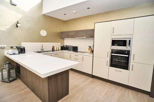 a kitchen with white cabinets and a white counter top at 1 The Kings within the City Walls in York
