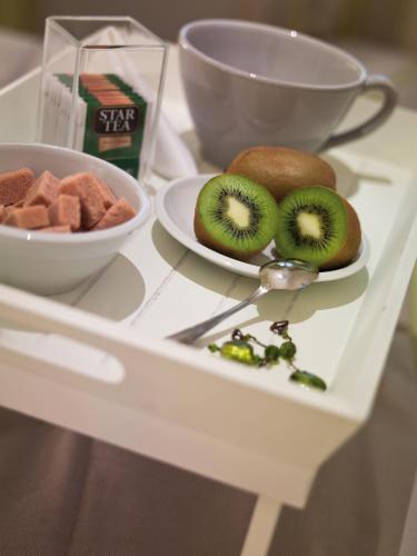 een tafel met een bord kiwi's en een fruitschaal bij Le Stanze Di Orazio in Rome