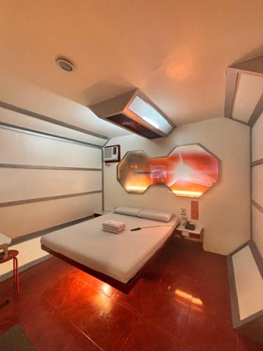 a small bedroom with a bed in a room at Astrotel Cubao in Manila