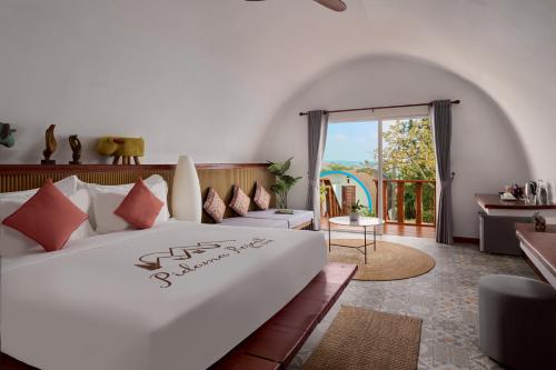 a bedroom with a white bed and a balcony at Pidoma Resort by EHM in Senmonorom