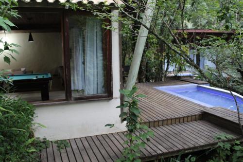 a deck with a swimming pool next to a house at Residencial Warabi in Visconde De Maua