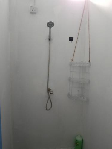 a shower in a white wall with a shower head at Gaharu glamping park in Jerantut
