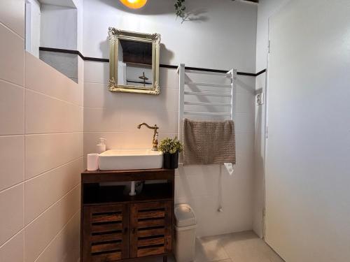 a bathroom with a sink and a mirror at Dandelion Vintage in Nemesgulács