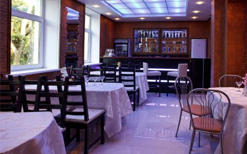 une salle à manger avec des tables et des chaises ainsi qu'un bar dans l'établissement Roza Vetrov, à Pereslavl-Zalesski