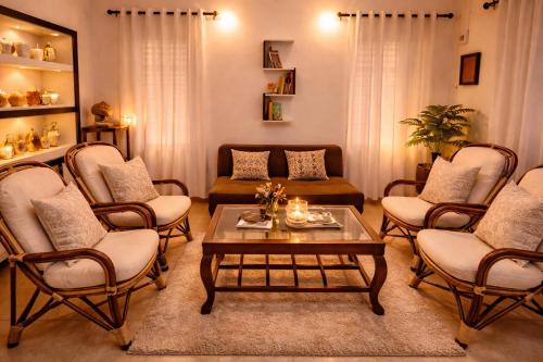 a living room with chairs and a coffee table at Best Homestay in Alappuzha 4 BR- LAYANILA in Alleppey