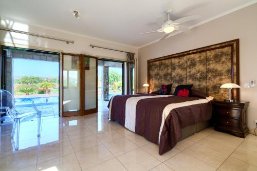 a bedroom with a bed and a sliding glass door at 5 bedroom Villa Rio with large private pool and hot tub, Aphrodite Hills Resort in Kouklia