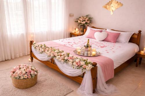 a bedroom with a large bed with flowers on it at Best Homestay in Alappuzha 4 BR- LAYANILA in Alleppey