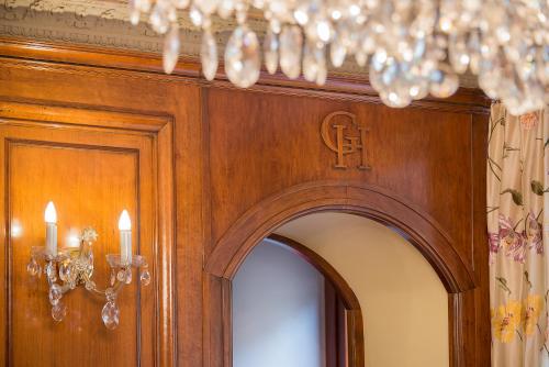 a room with a wooden wall with a chandelier at Grotthuss Boutique Hotel Vilnius in Vilnius