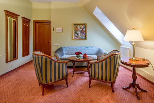 a living room with a couch and a table and chairs at Grotthuss Boutique Hotel Vilnius in Vilnius