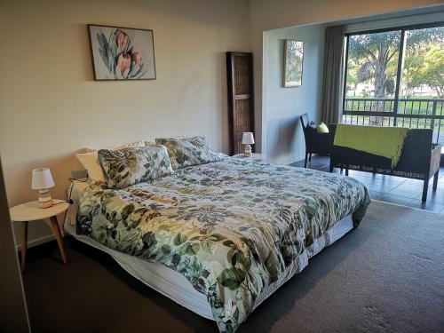 a bedroom with a bed and a table and a window at Tutukaka Marina Views in Tutukaka