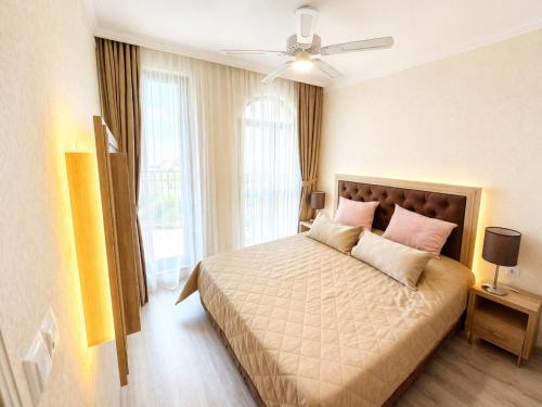a bedroom with a large bed with pink pillows at Harmony 20 Sveti Vlas Private Apartment 211 in Sveti Vlas