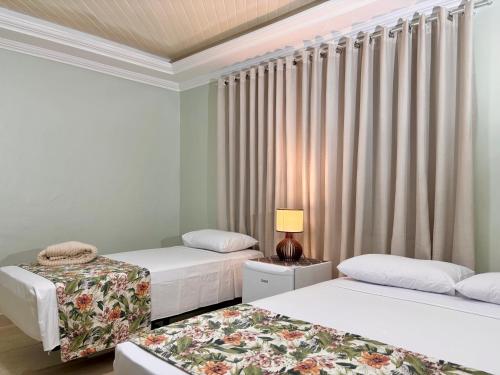 two beds in a room with curtains at Julietta House Hotel in Manaus