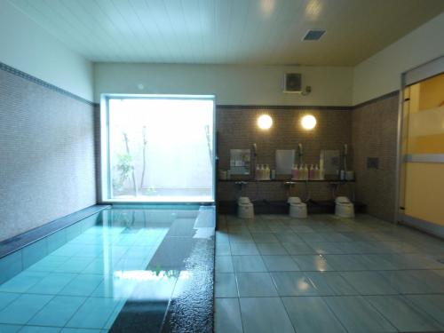 a bathroom with two toilets and a swimming pool at Hotel Route-Inn Nakatsu Ekimae in Nakatsu