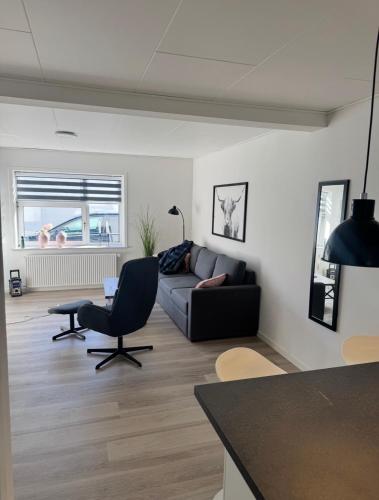 a living room with a couch and a chair at Finnsvej 12E in Frederikshavn