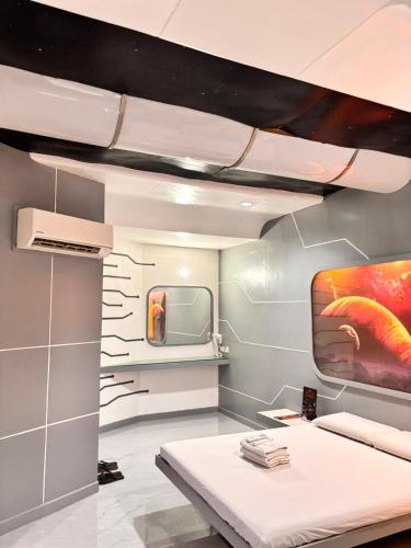 a room with a bed and a tv on a wall at Astrotel Cubao in Manila