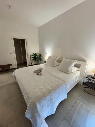 a large white bed with a pair of shoes on it at Tahiti Ethnik 2 bedrooms AC Pool in Punaauia
