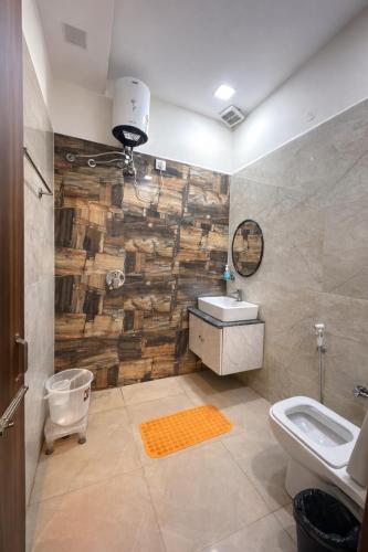 a bathroom with a wooden wall with a sink and a toilet at The WoodLuck Zirakpur Chandigarh - Sidham Group of Hotels in Chandīgarh