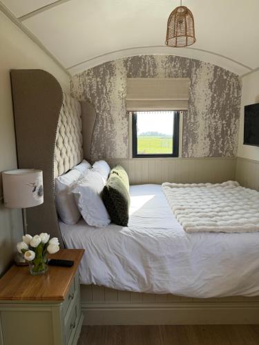 a bedroom with a large white bed with a window at The Shepherds Chalet in Garstang