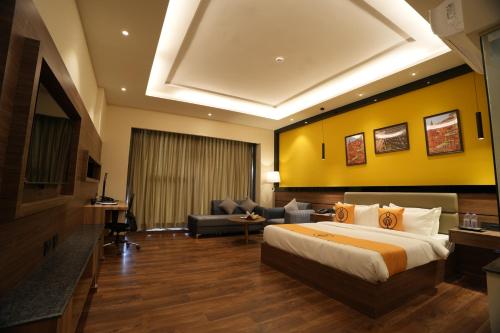 a hotel room with a bed and a yellow wall at The Murti Hotel and Banquet in Noida