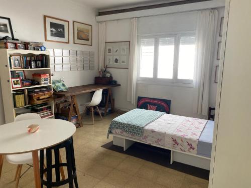 a bedroom with a bed and a table and a desk at La Santiaga Sólo para chicas in Córdoba